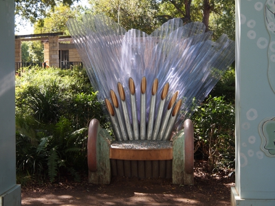 [A bench with what appears to be clear fins or wings emanating from the back behind tubes which form the back of the chair. This chair sits at one end of the castle.]